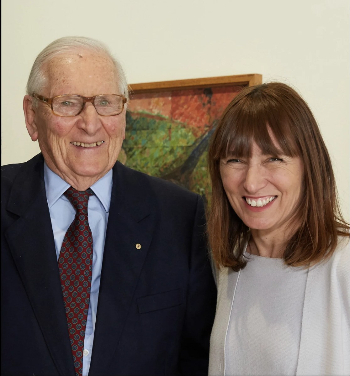 Elderly man in a suit and tie with a younger woman with dark hair. Vale Michael Gleeson-White