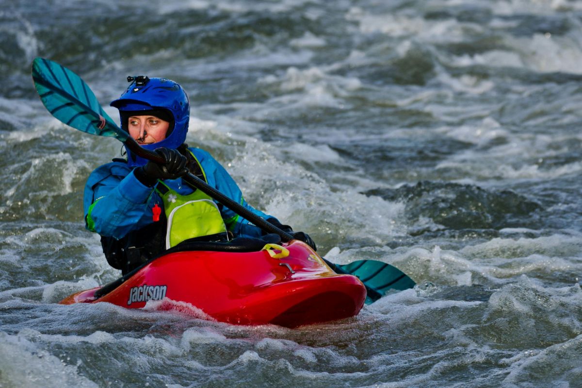 A woman kayaking in a fast-flowing, choppy river. arts sector appoinments
