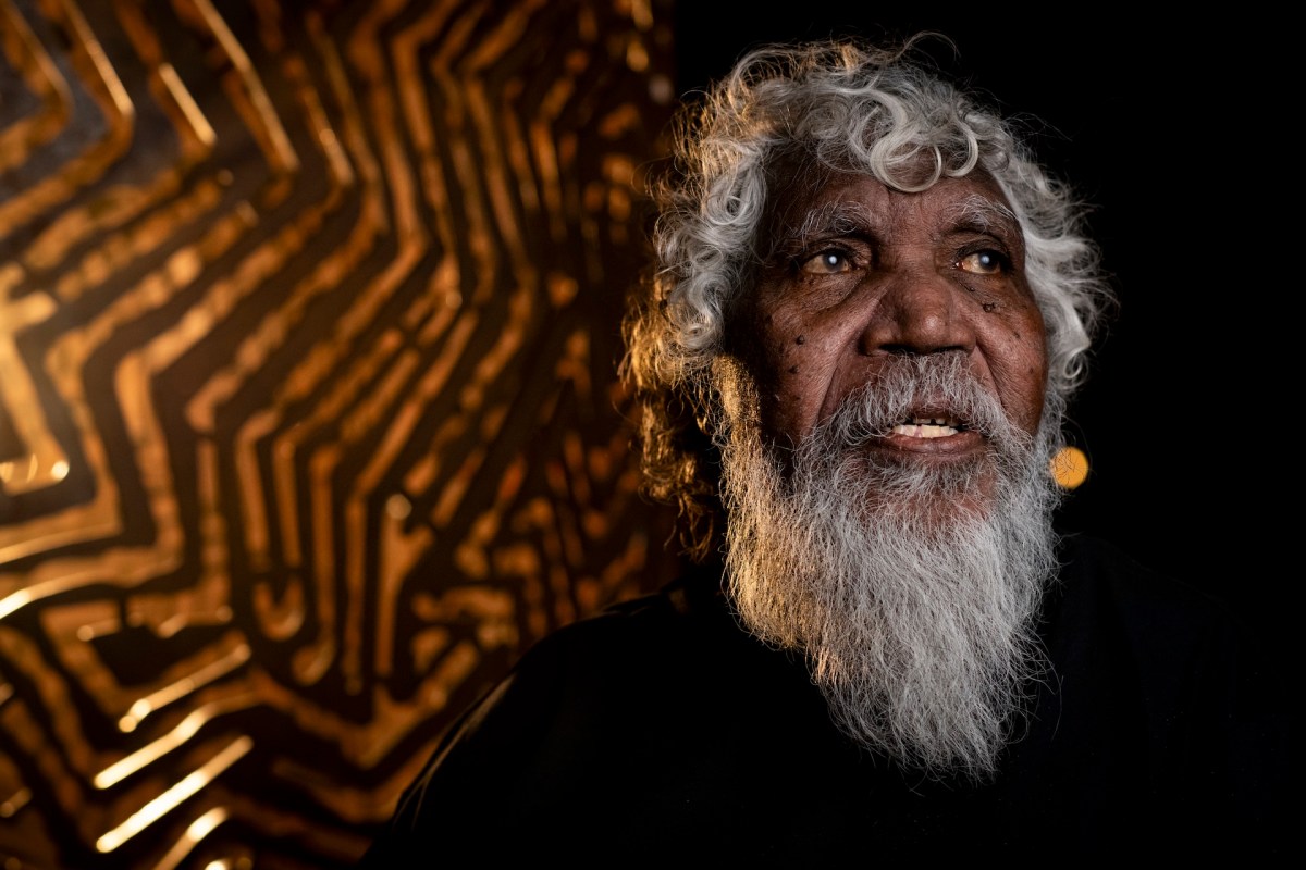 Bobby West Tjupurrula stands in front of his installation Hypnotic Reverberations at Parrtjima 2025. Image: Parrtjima Festival. 