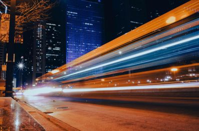 Blurred headlights and tail lights from cars and trucks passing at speed draw a series of vivid parallel lines in a long exposure photograph of a city street at night. arts sector appointments,