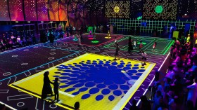 Moment Factory's larger-than-life video games experience Augmented Games has been programmed for Illuminate Adelaide 2026. People watch on from the sides as participants step onto the boards of immersive, large-scale video games.