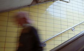 A blurred figure hurries down a tiled staircase, perhaps to catch a train. arts sector appointments