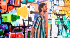 Sam Kissajukian in front of his art during a performance of 300 Paintings. Photo: Sarah Findlay.