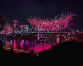Riverfire by Australian Retirement Trust returns for Brisbane Festival 2026. Fireworks light up Brisbane's skyline and bridges at night, and are reflected in the Brisbane River.