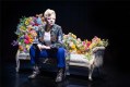 Sydney Theatre Company: a photo of actor Sarah Snook playing Dorian Gray sitting on an elaborately decorated chaise longue. The chaise longue is decorated in flowers.
