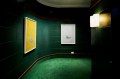 Aster + Asha Gallery exhibition of Anna Richardson's work. A darkened bright green hallway space showing two frmaed artworks on the wall under spotlights.